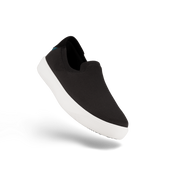 Black slip-on sneaker with white sole on a white background