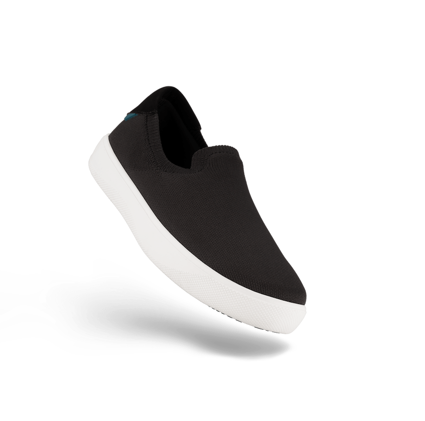 Black slip-on sneaker with white sole on a white background
