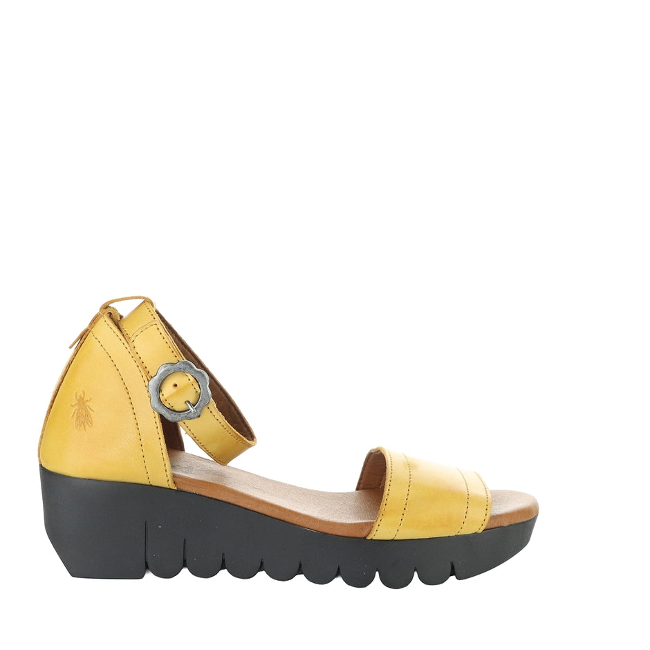 Yellow sandal with a black sole on a white background