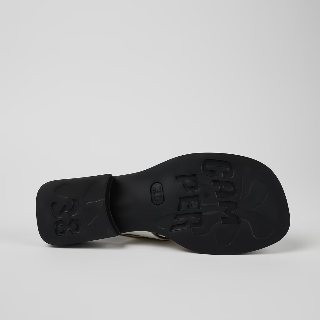 Black sandal sole with brand name on a light gray background