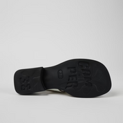 Black sandal sole with brand name on a light gray background