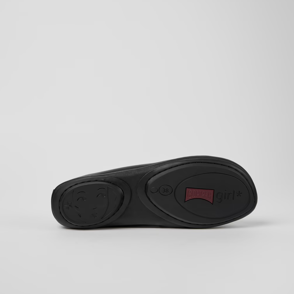 Black shoe sole with a red label on a light gray background