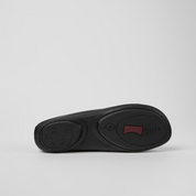 Black shoe sole with a red label on a light gray background