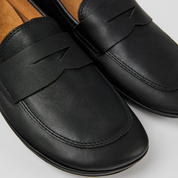 Black loafers on a light gray background