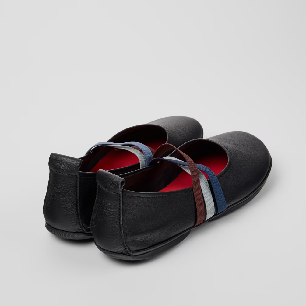 Black loafers with colorful interior on a light gray background