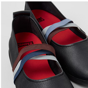 Black shoes with colorful straps on a light gray background