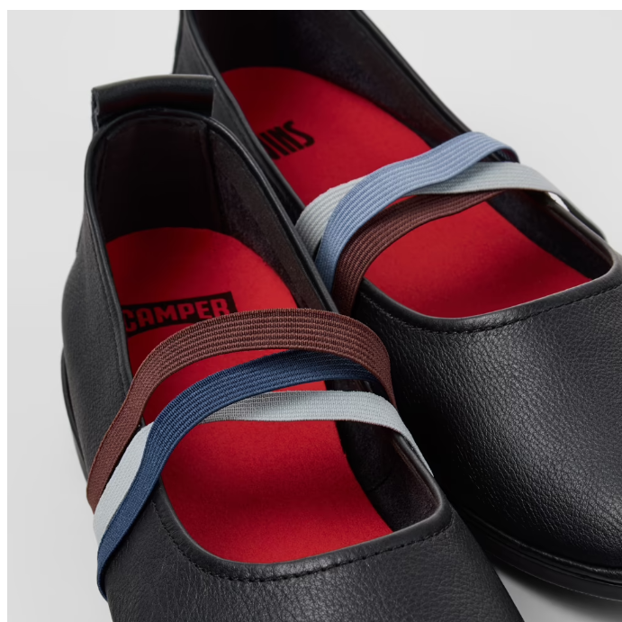 Black shoes with colorful straps on a light gray background