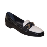 Black and white loafer shoe with a gold buckle on a white background