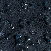 Close-up of dark sand with water droplets on a blue background
