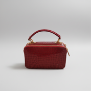 Red handbag with gold accents on a white background