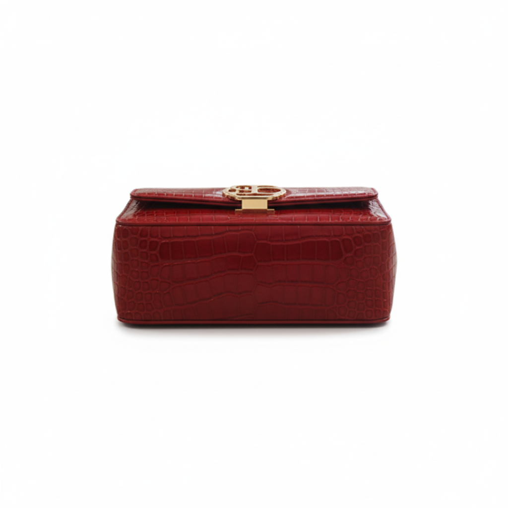 Red crocodile-patterned handbag with a gold clasp on a white background