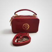 Red handbag with a strap on a white background