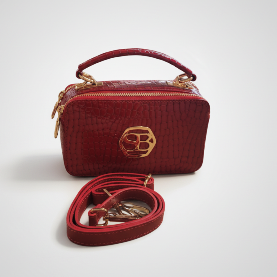 Red handbag with a strap on a white background