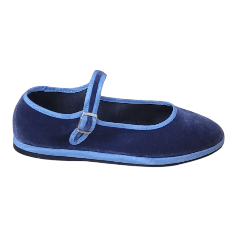 A navy blue velvet Mary Jane flat shoe with light blue trim and a small silver buckle, shown from a side profile on a white background.