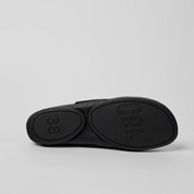 Black sandal with '38' and brand name on a light gray background