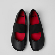 Black shoes with red soles on a light gray background