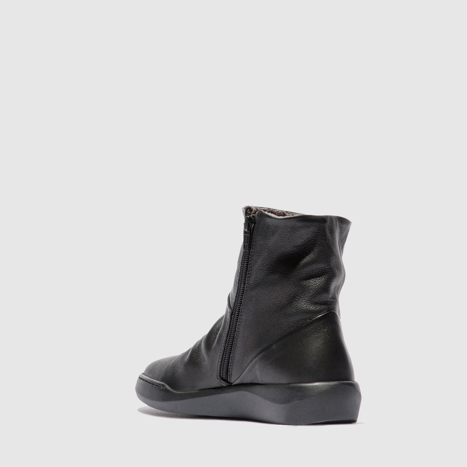 Black leather boot on a light gray background