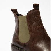 Brown leather boot with a green patch on a white background
