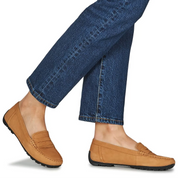 tan loafers worn with blue jeans on a white background