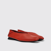 Pair of red shoes on a light gray background