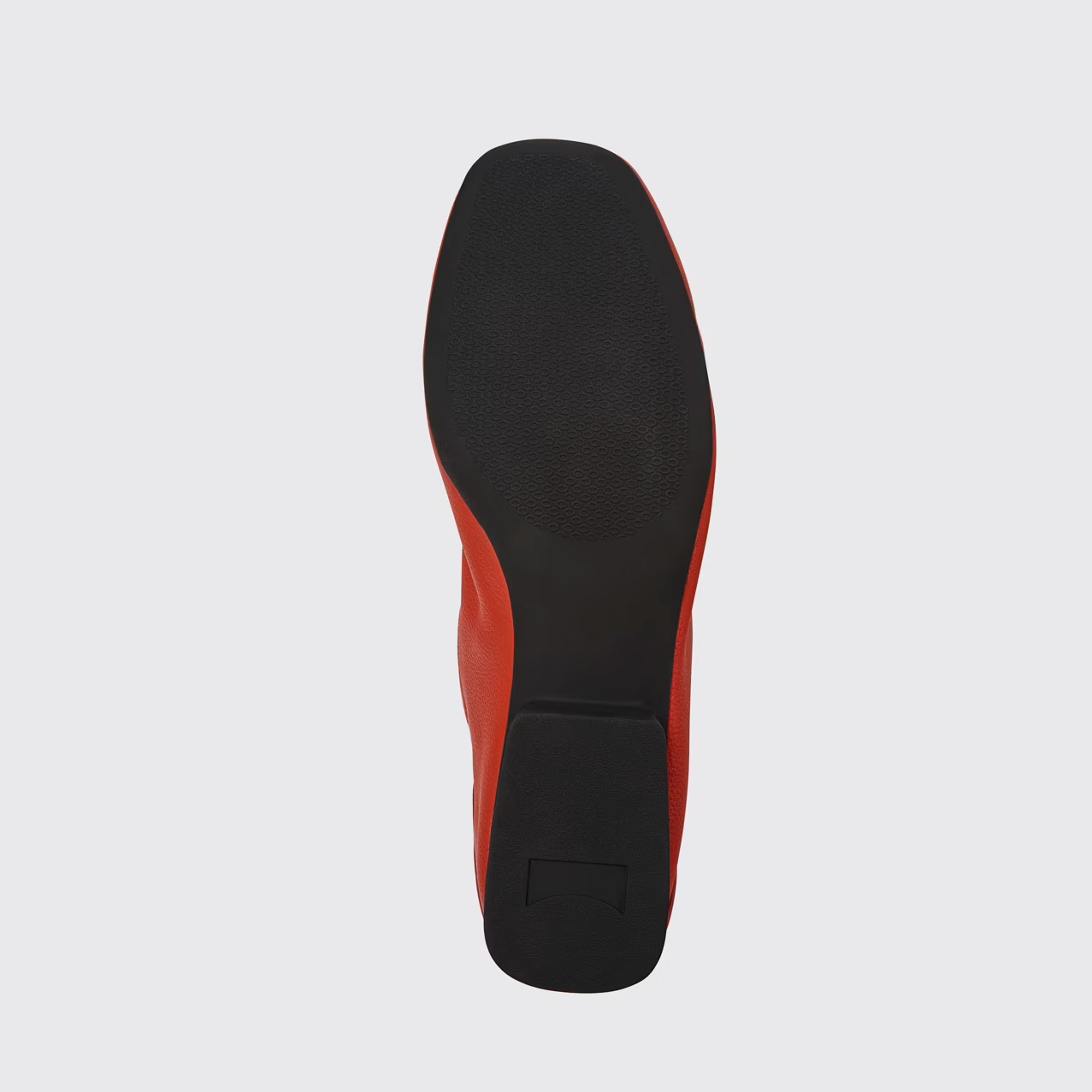 Black and red shoe sole on a light gray background
