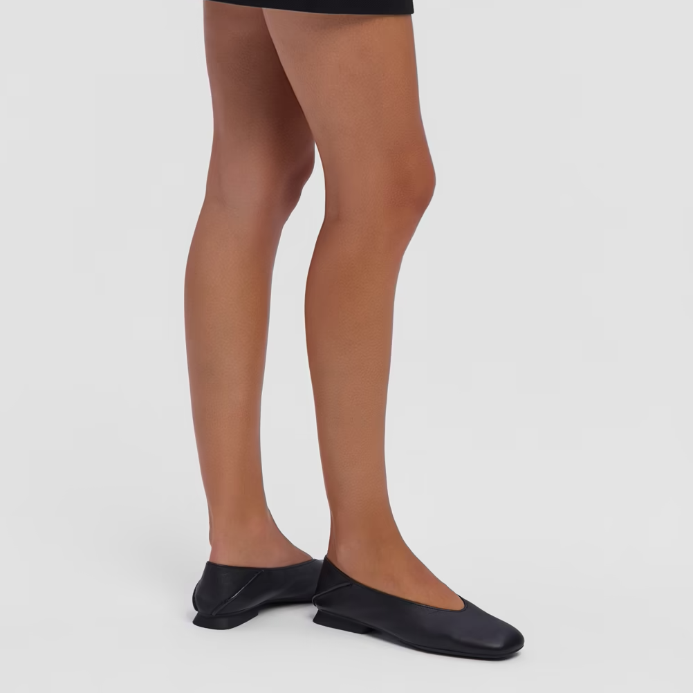 Person wearing black tights and shoes on a white background
