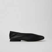 Black flat shoe on a light gray background