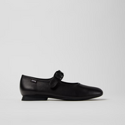Black shoe with a bow on a light gray background