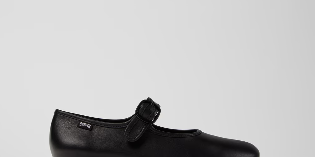 Black shoe with a bow on a light gray background