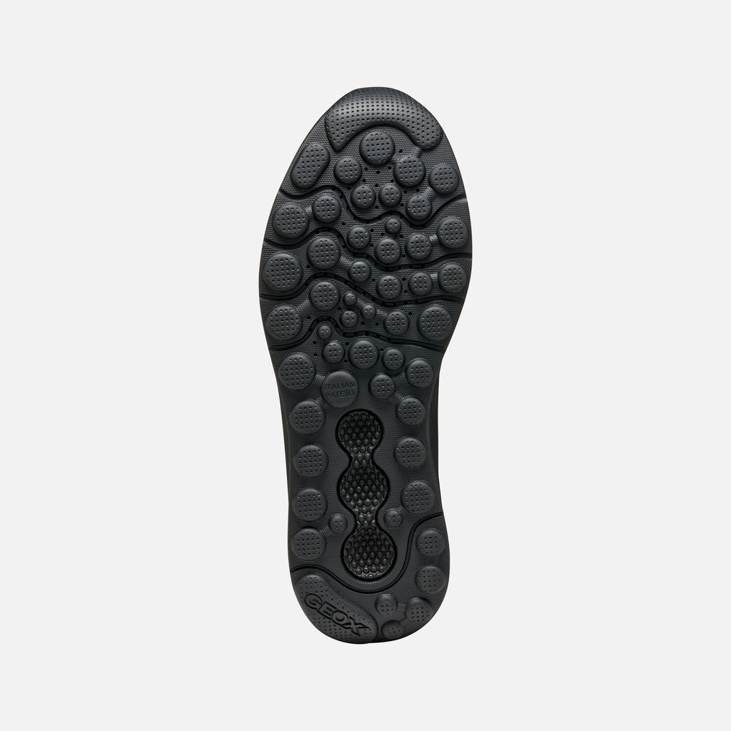 Close-up of a black shoe sole on a light gray background