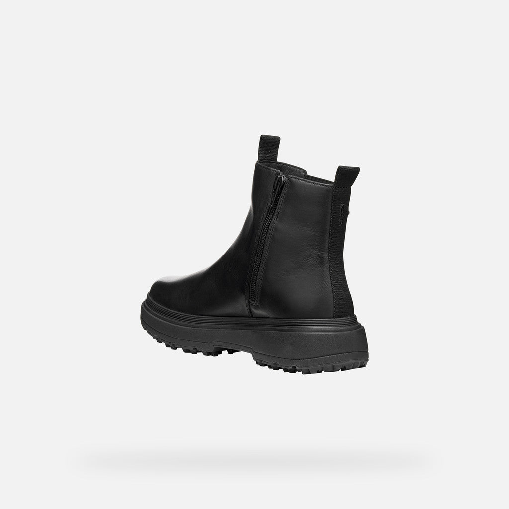 Black Chelsea boot on a light gray background