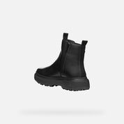 Black Chelsea boot on a light gray background