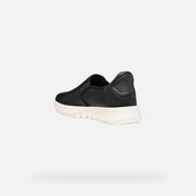Black slip-on sneaker with white sole on a light gray background