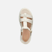 White sandal with multiple straps on a light gray background