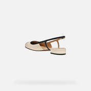 Beige sandal with black strap on a white background