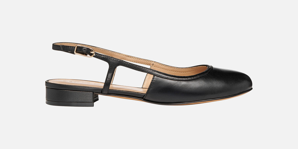 Black slingback flat shoe on a light gray background