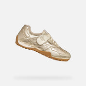 Gold sneaker with brown sole on a white background