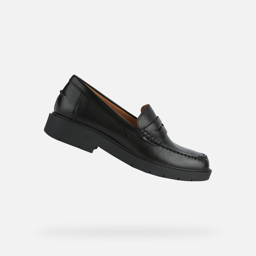 Black loafer shoe on a light gray background