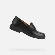 Black loafer shoe on a light gray background