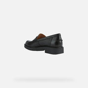 Black loafer shoe on a light gray background