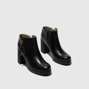 Pair of black ankle boots on a light gray background