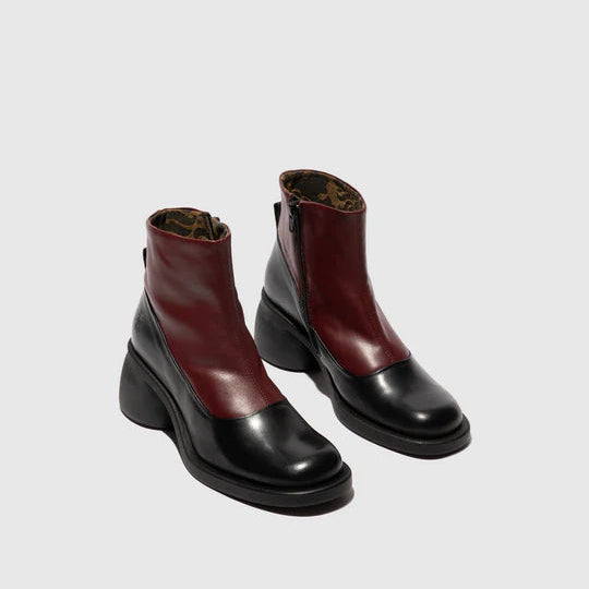 Pair of black and burgundy ankle boots on a light gray background