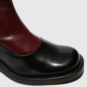 Black and burgundy leather boot on a light gray background