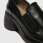 Black leather loafer shoe on a light gray background