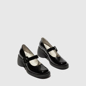 Pair of black patent leather shoes with buckles on a light gray background