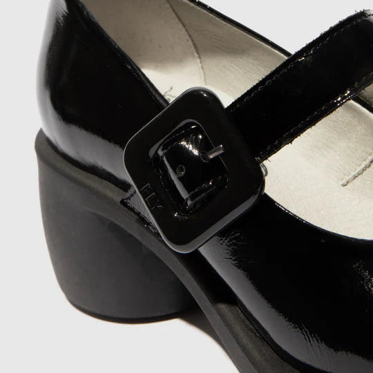 Black patent leather shoe with a buckle on a light gray background