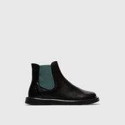 Black Chelsea boot with green inner lining on a light gray background