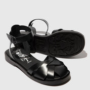 Black sandals with a brand logo on a light gray background