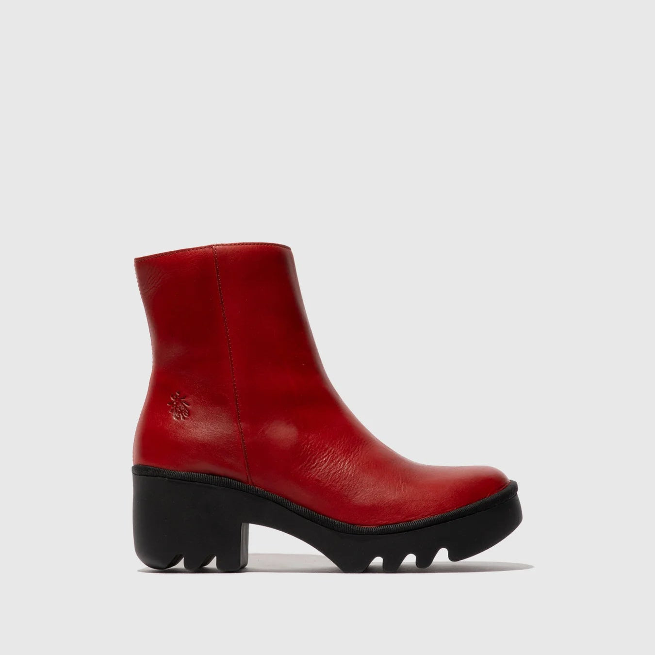 Red ankle boot with a black sole on a light gray background