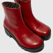 Pair of red ankle boots on a light gray background
